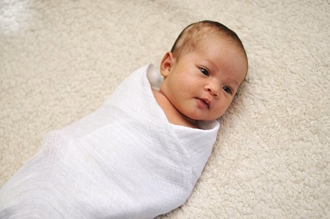 membedong bayi